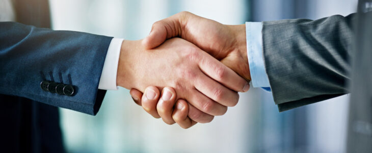 Closeup shot of two businessmen shaking hands in an office