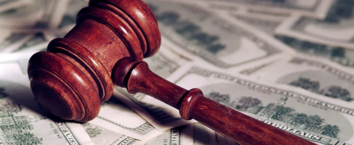 A red gavel on a pile of money.