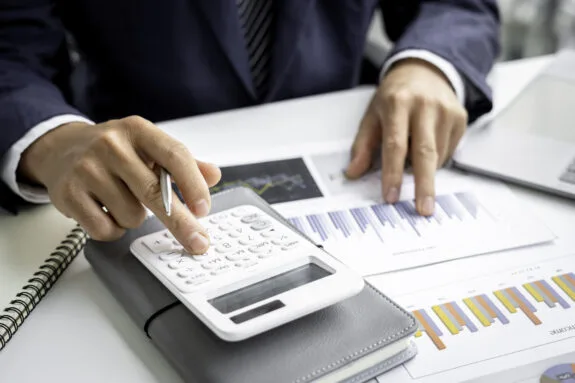 Man in a business suit using a calculator